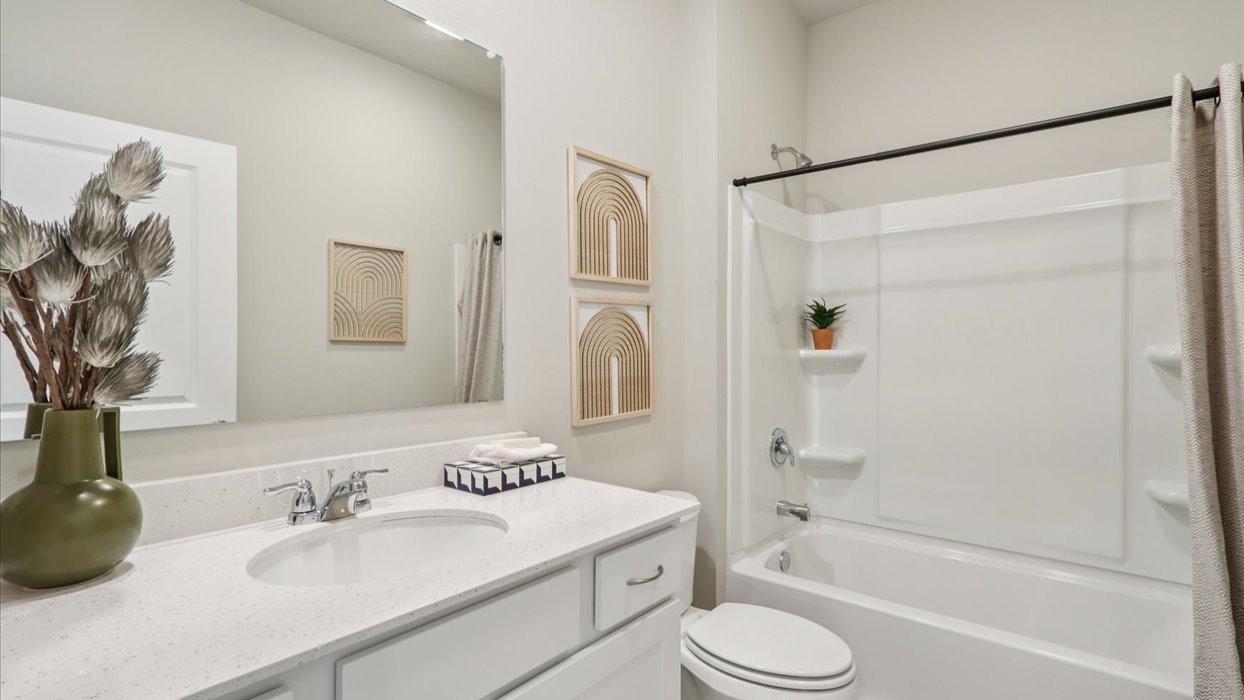 Bathroom with tub and shower combo, quartz countertops, and white vanity