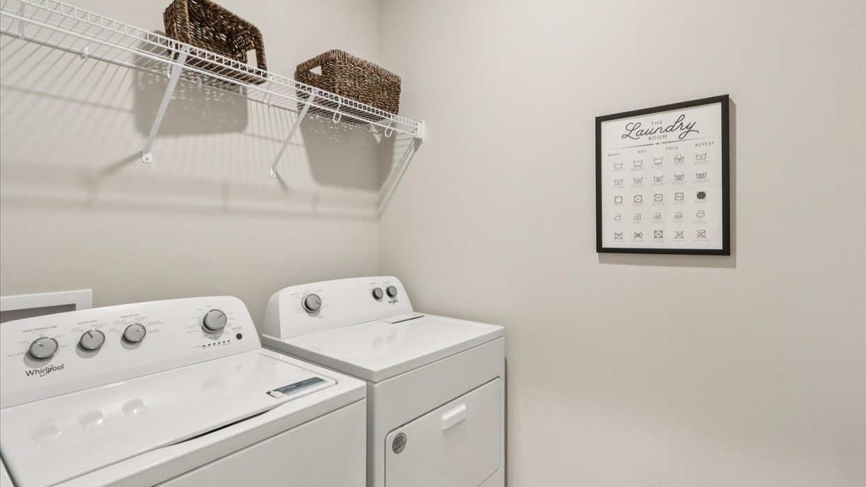Dedicated laundry room with built-in shelving and utility connections.