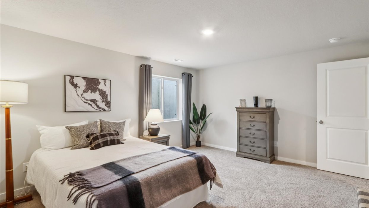 Private lower-level bedroom with natural light and functional storage space.