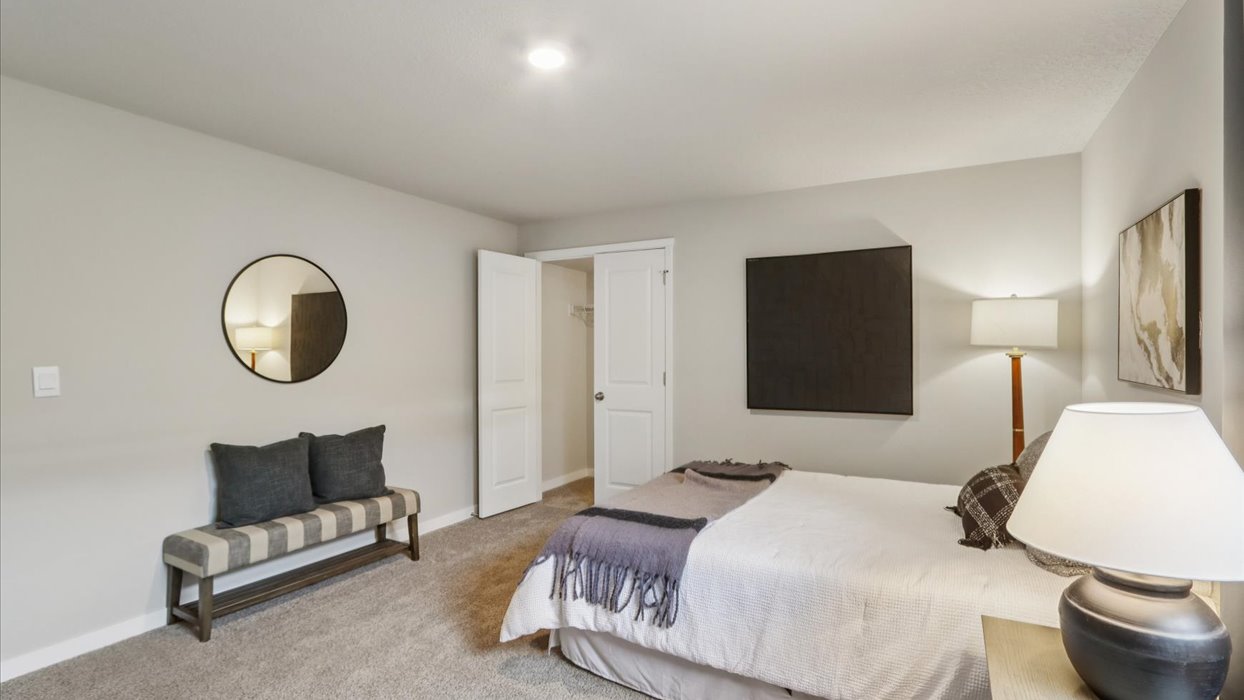 Private lower-level bedroom with natural light and functional storage space.