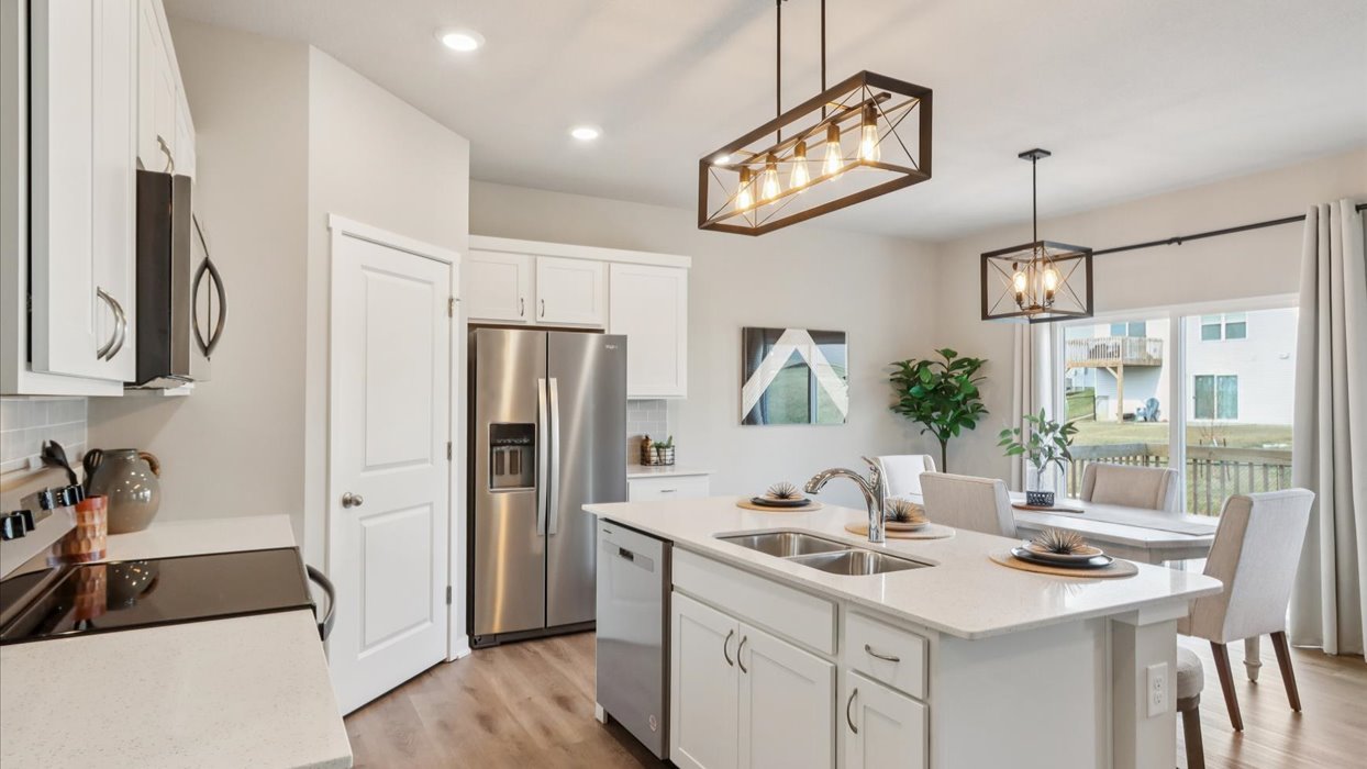 Kitchen with stainless steel appliances, quartz countertops, and white cabinetry