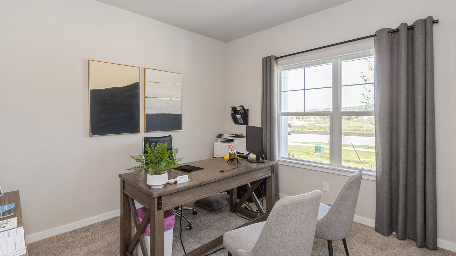 first bedroom staged as an office with desk and chairs