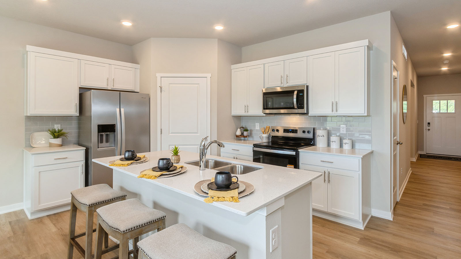 modern white kitchen with island and stainless-steel appliances