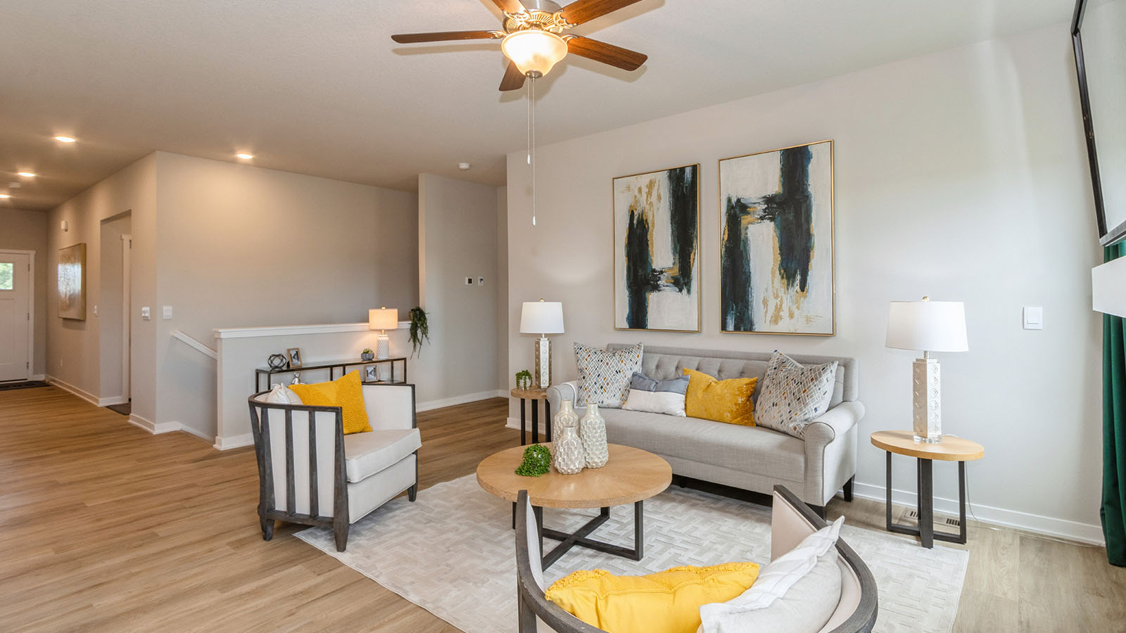 living room with ceiling fan and small grey loveseat with chair
