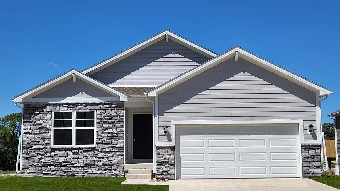 Exterior photo of the hamilton one-story plan with grey siding, stone on the front of the house and a two-car garage