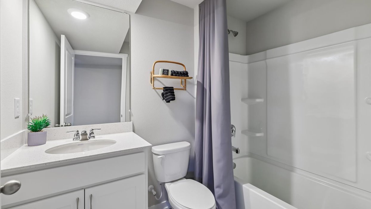Bathroom with tub and shower combo, quartz countertops, and white vanity