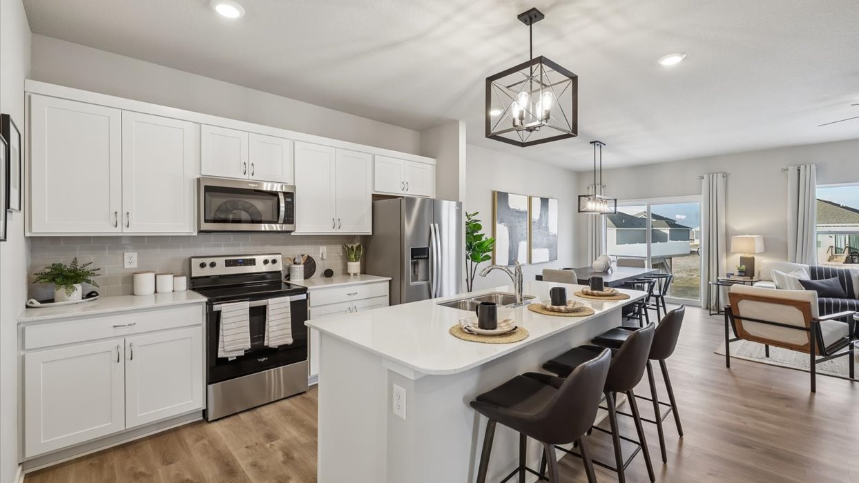 Kitchen with stainless steel appliances, quartz countertops, and white cabinetry