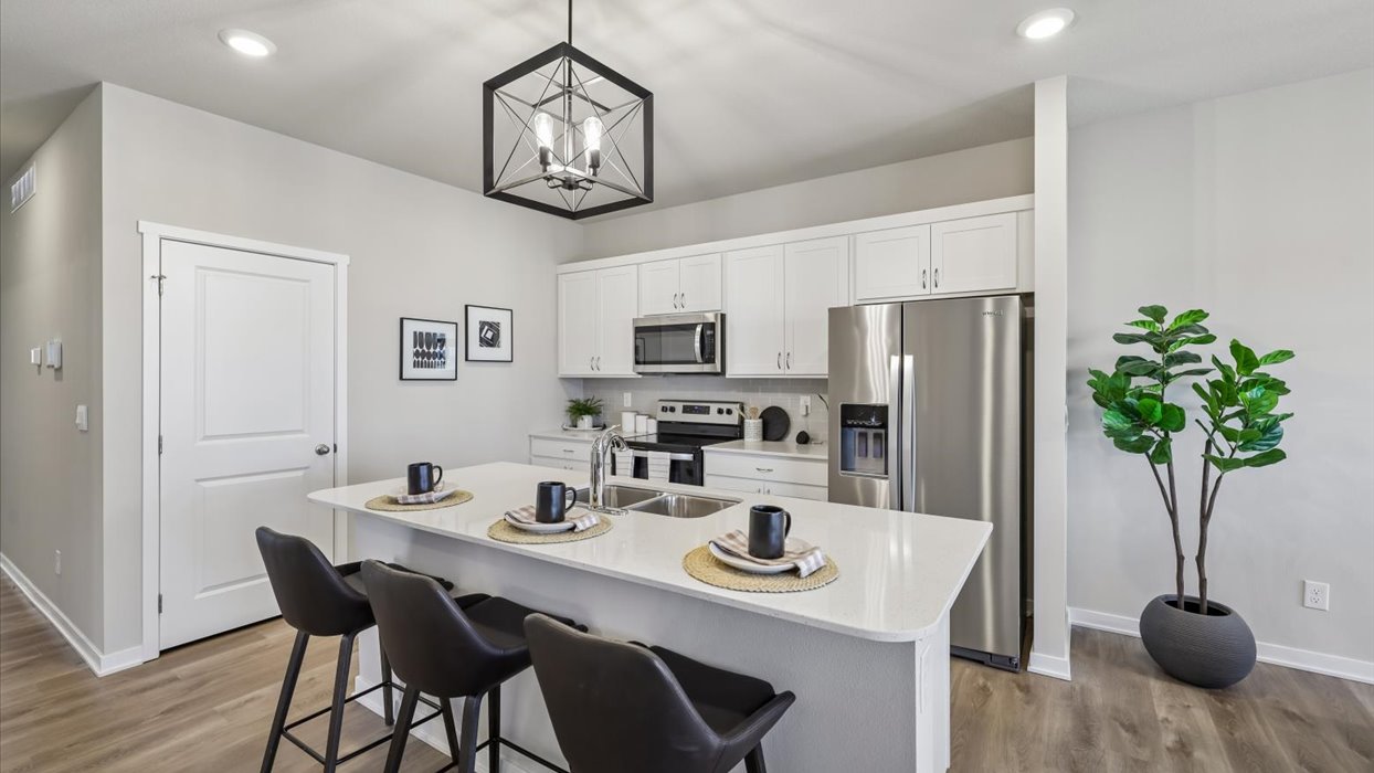 Kitchen with stainless steel appliances, quartz countertops, and white cabinetry