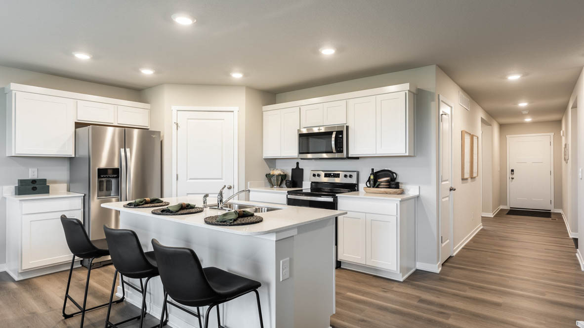 Kitchen with stainless steel appliances, quartz countertops, and white cabinetry