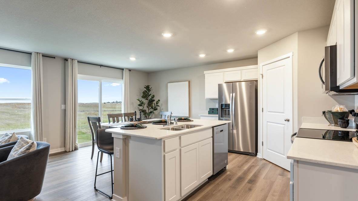 Kitchen with stainless steel appliances, quartz countertops, and white cabinetry