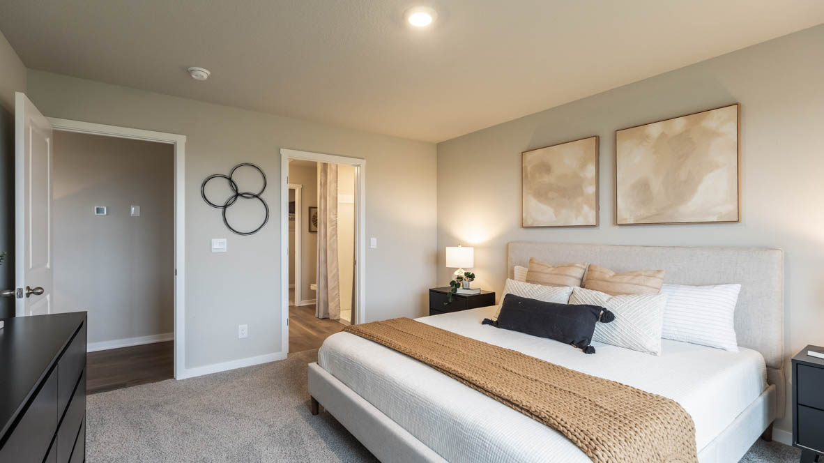 Spacious primary suite with natural light, attached bathroom, & walk in closet