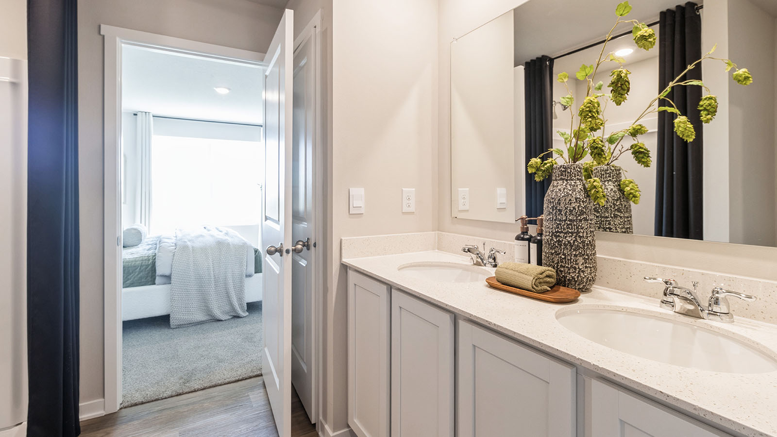 Spacious primary bathroom featuring dual vanities, modern fixtures, and a walk-in shower.