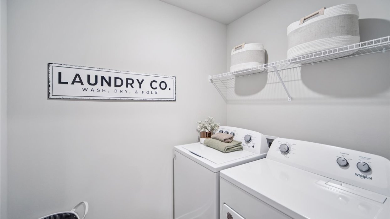 Dedicated laundry room with built-in shelving and utility connections.