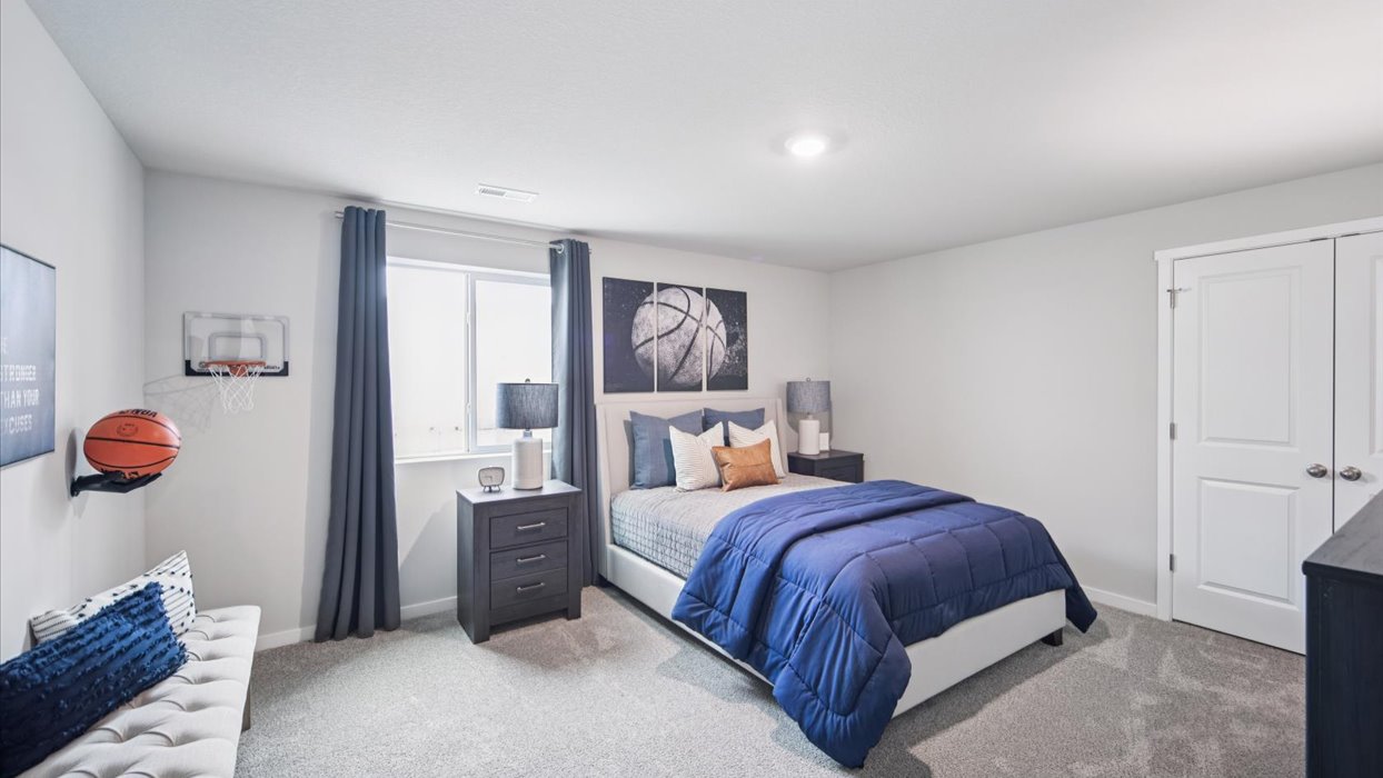 Private lower-level bedroom with natural light and functional storage space.