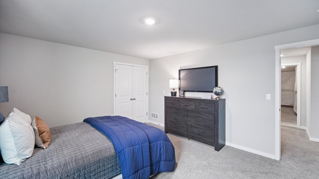 Private lower-level bedroom with natural light and functional storage space.