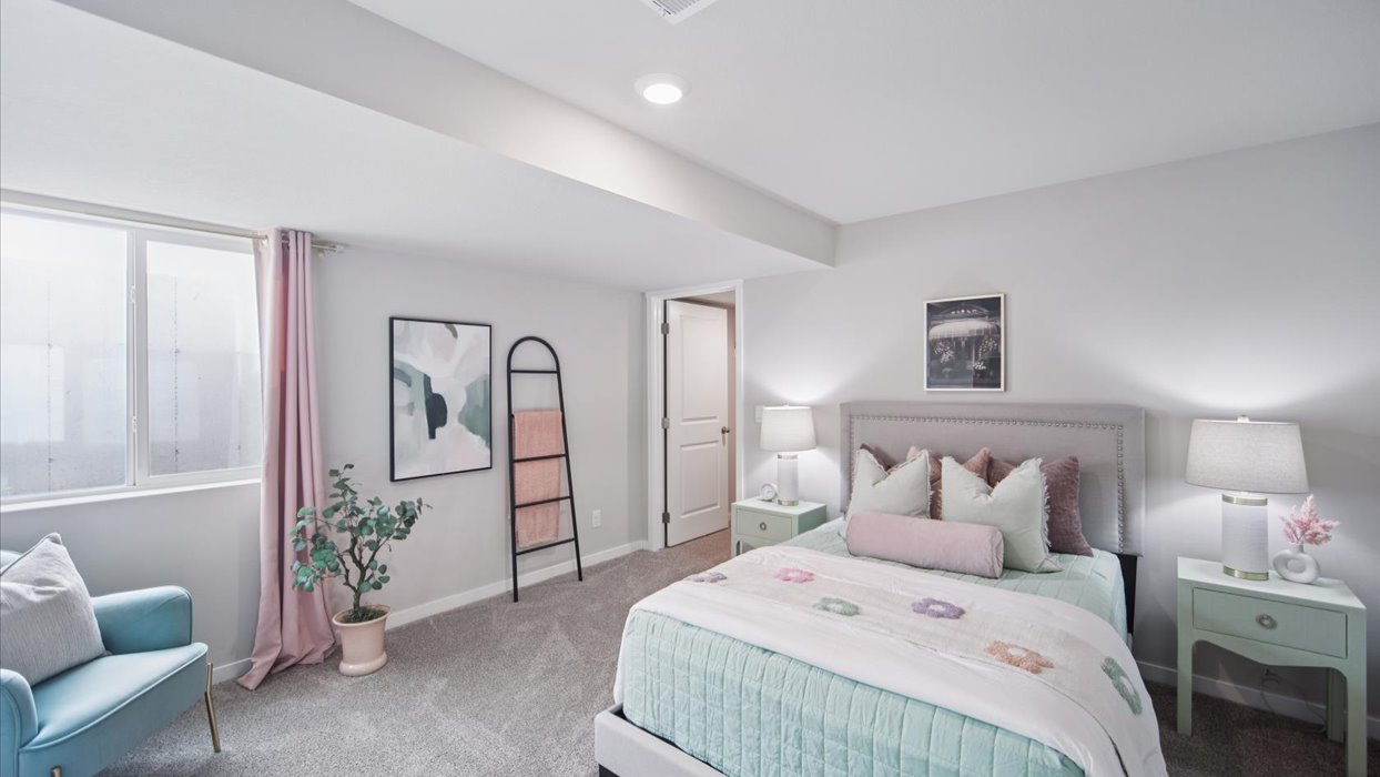 Private lower-level bedroom with natural light and functional storage space.