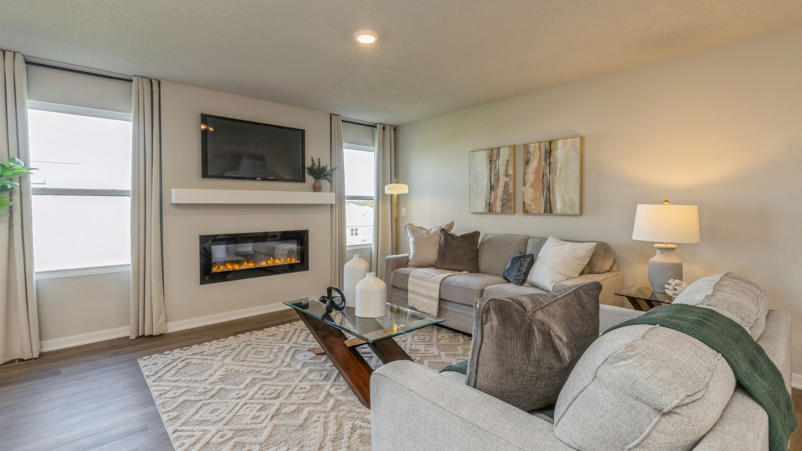 Bright living room with two large windows and two couches
