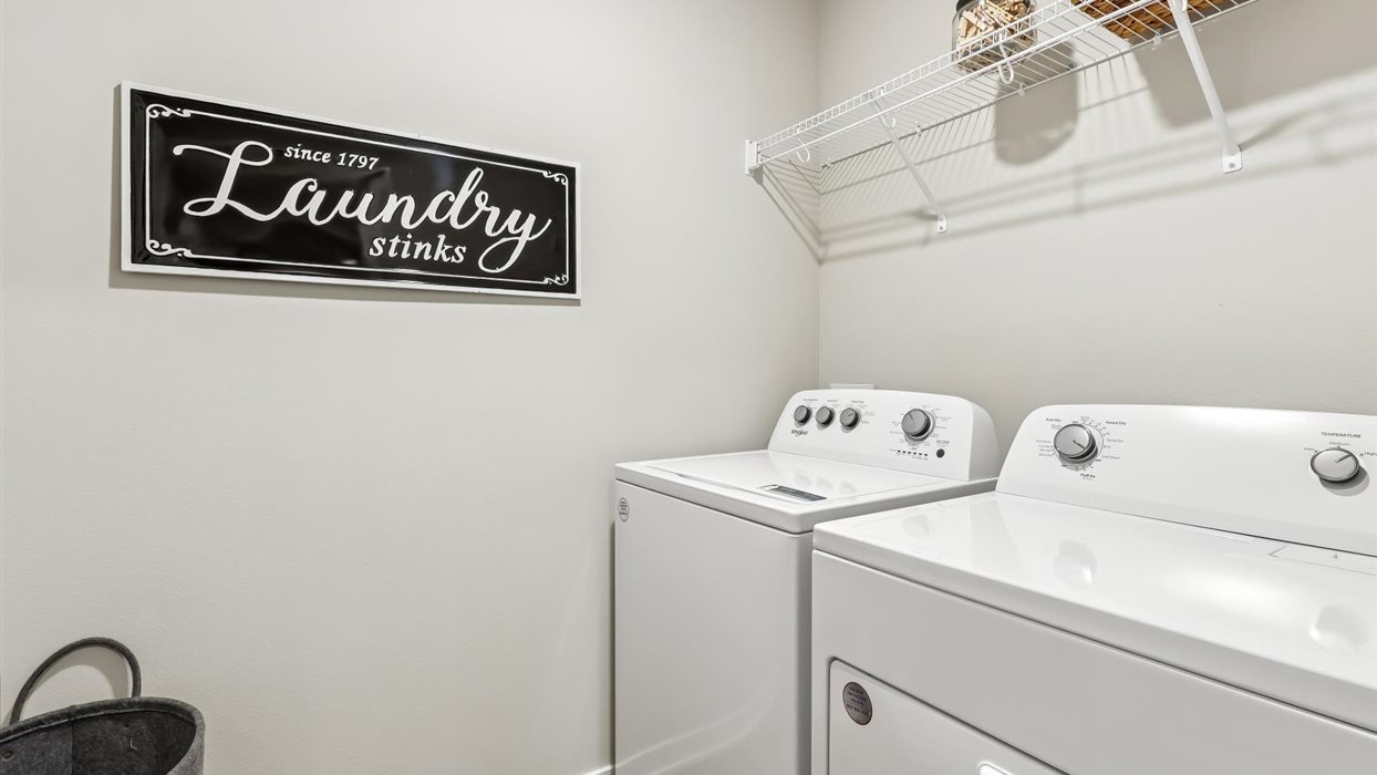 Dedicated laundry room with built-in shelving and utility connections.