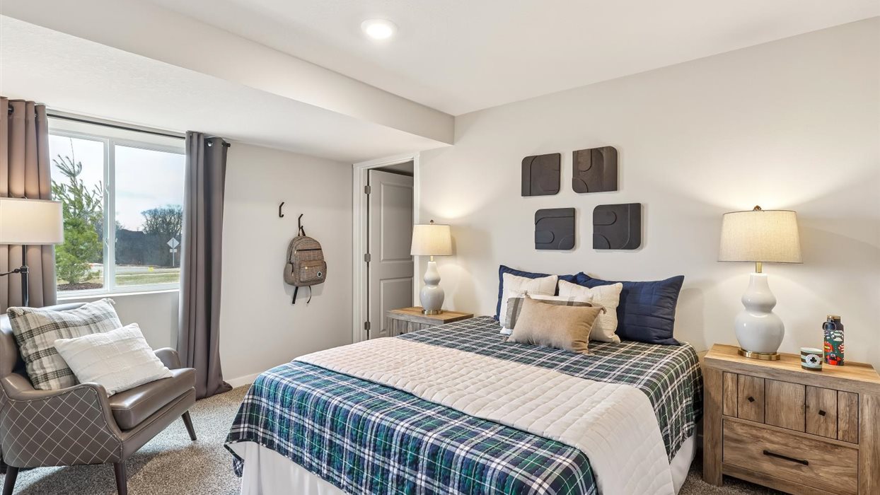 Private lower-level bedroom with natural light and functional storage space.