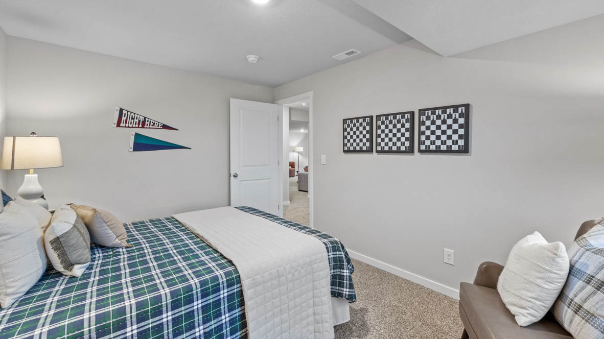 Private lower-level bedroom with natural light and functional storage space.