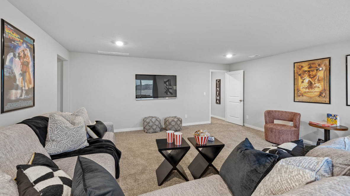 Finished basement with large sectional and two tables