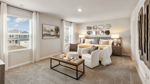 Primary bedroom in the Bellhaven with a king bed, seating area and coffee table