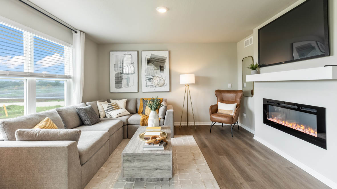 Living room in the Bellhaven with large sectional couch, coffee table and a fireplace