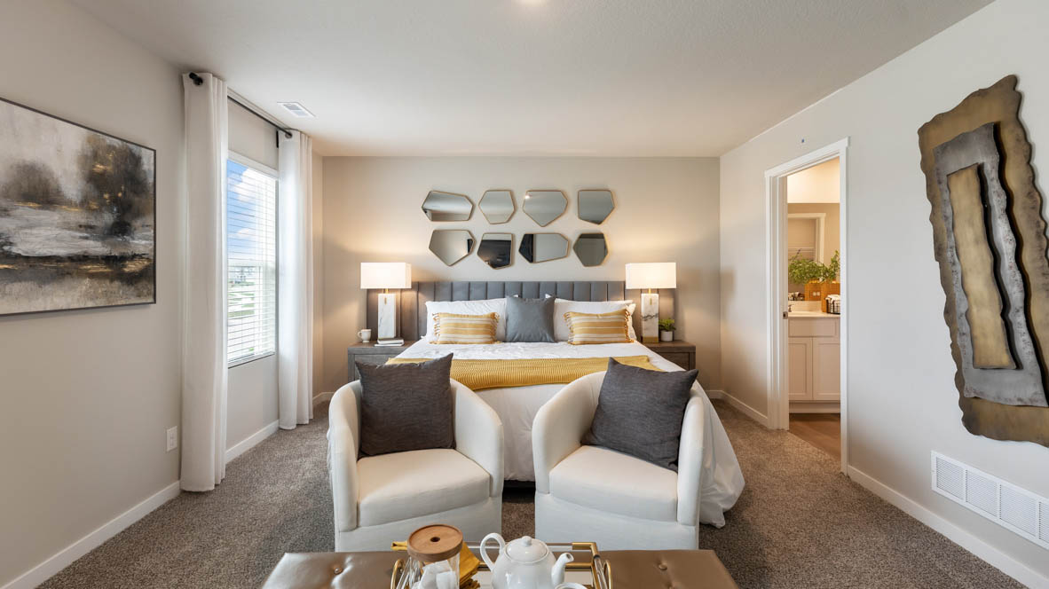 Primary bedroom of the Bellhaven showing the primary bathroom, closet, and seating area
