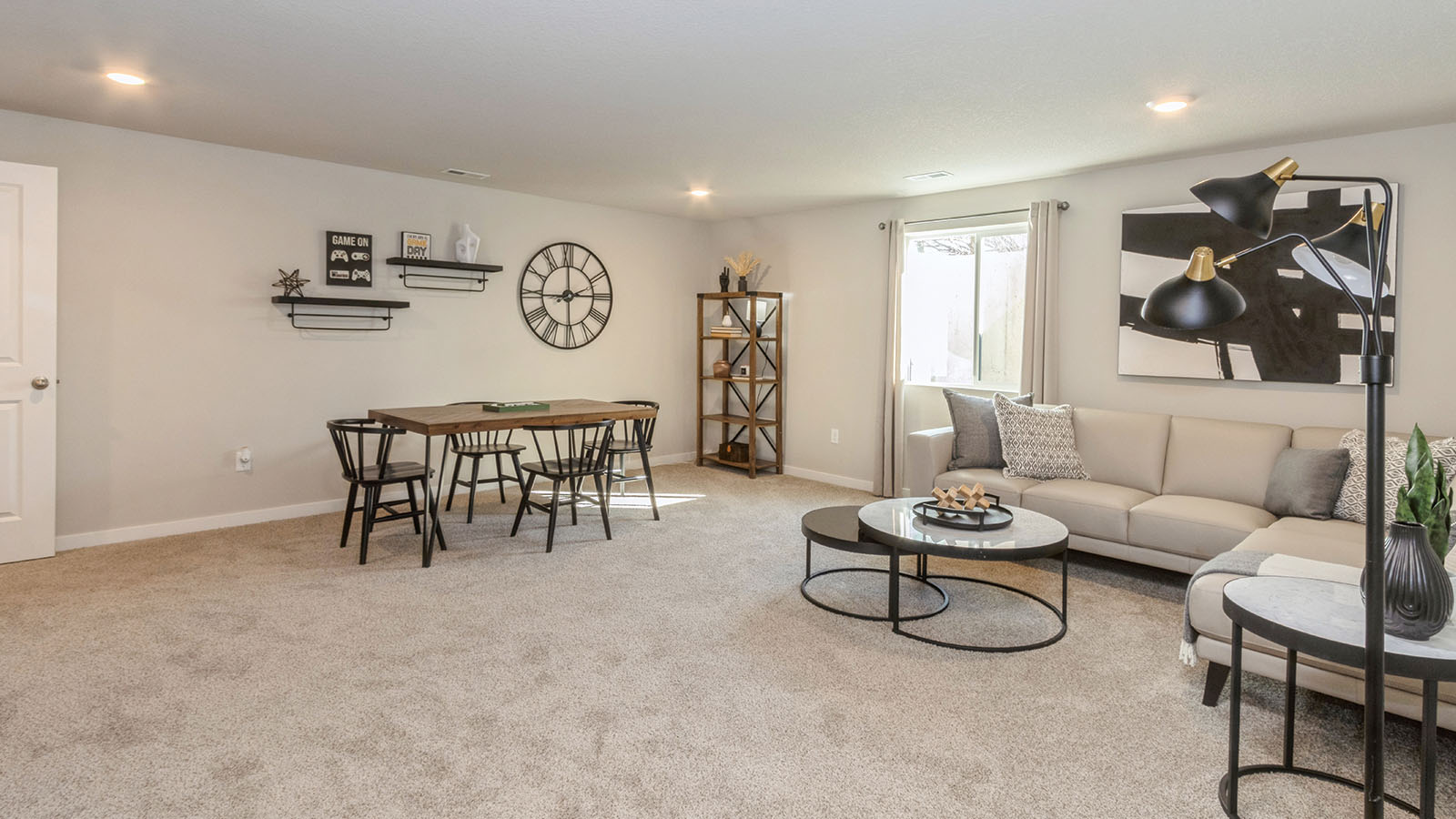 large finished basement with small window and couch with dining table and chairs
