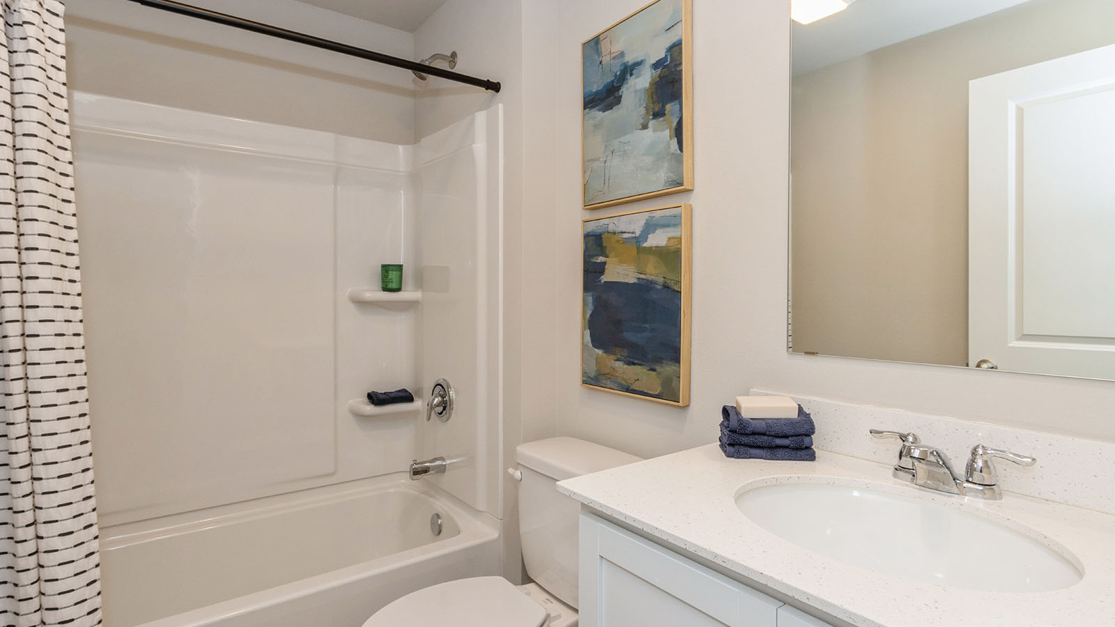 second bathroom with white cabinetry and shower and bathtub