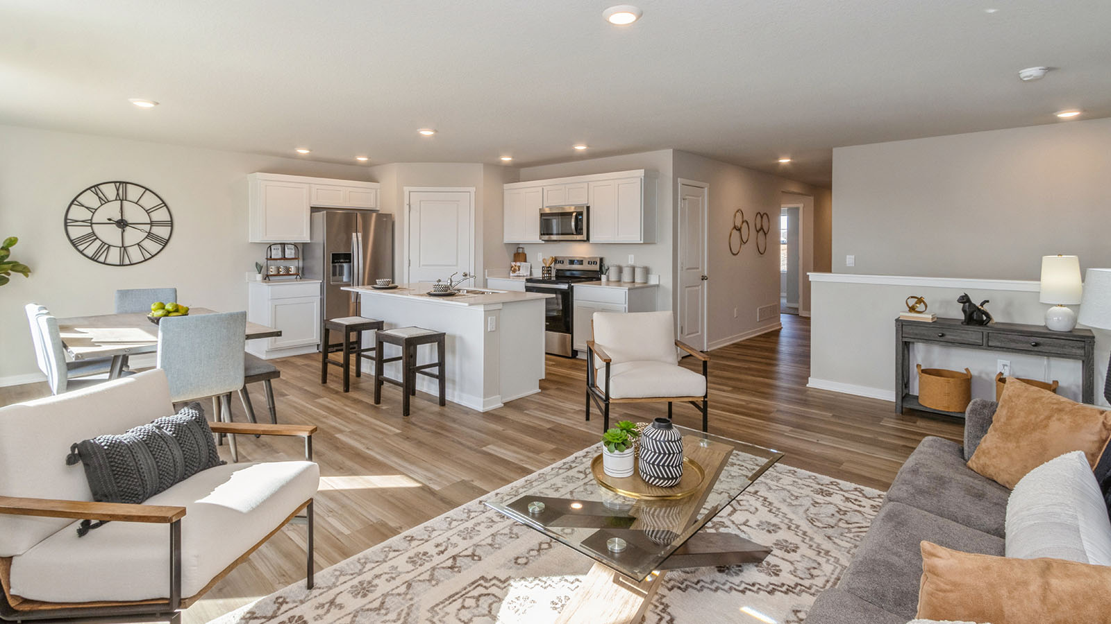spacious living room with grey couch overlooking dining area and kitchen