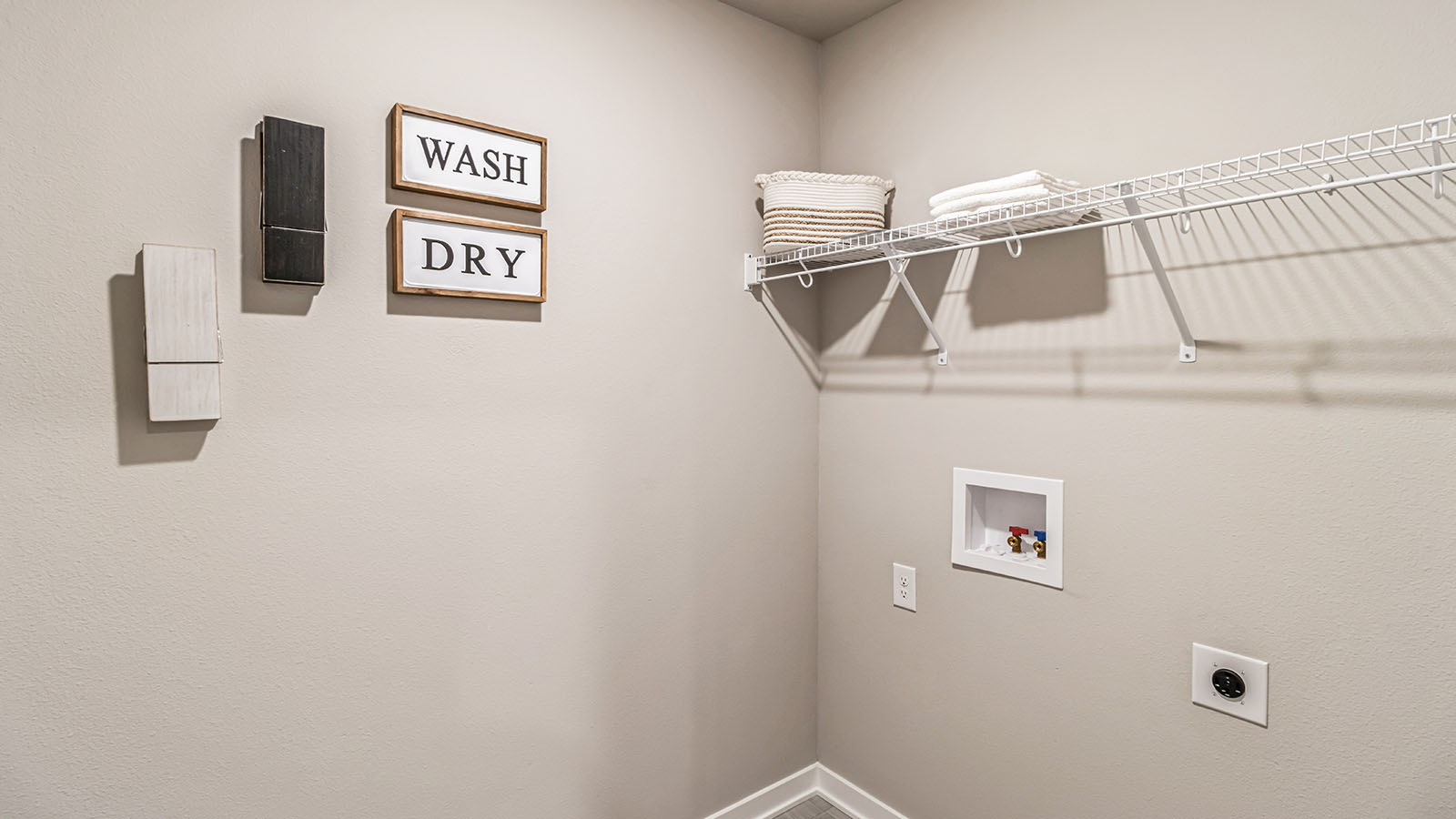 Dedicated laundry room with built-in shelving and utility connections.
