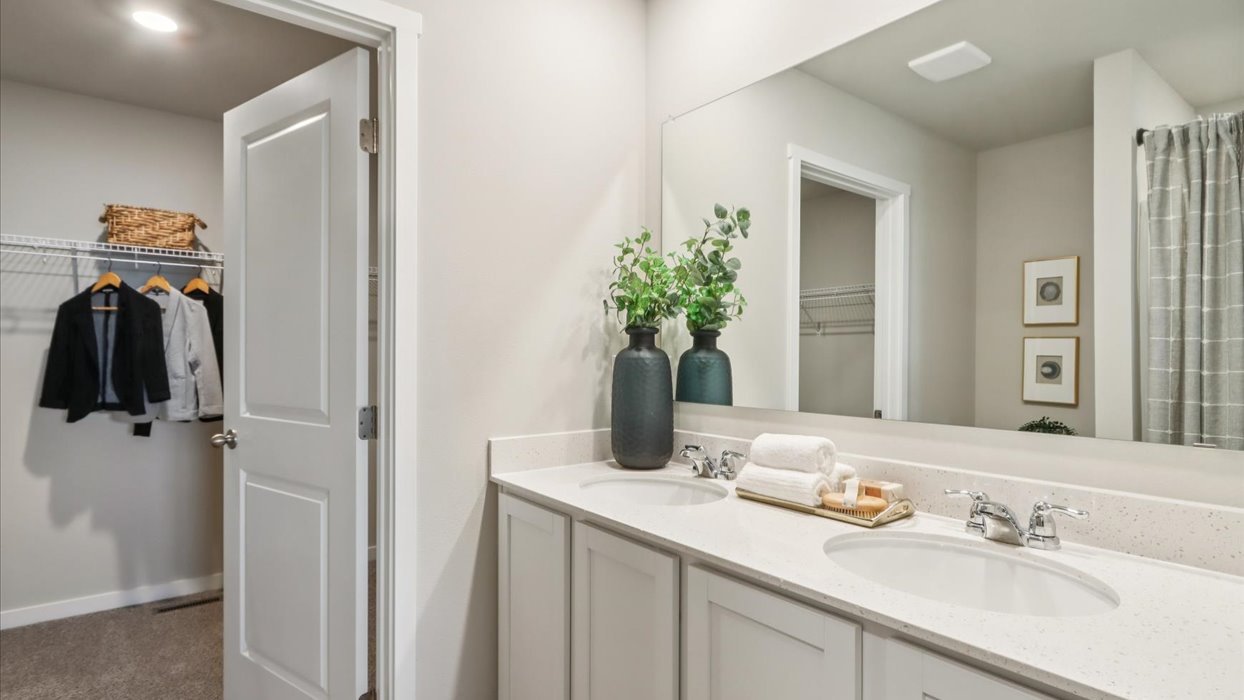 Spacious primary bathroom featuring dual vanities, modern fixtures, and a walk-in shower.