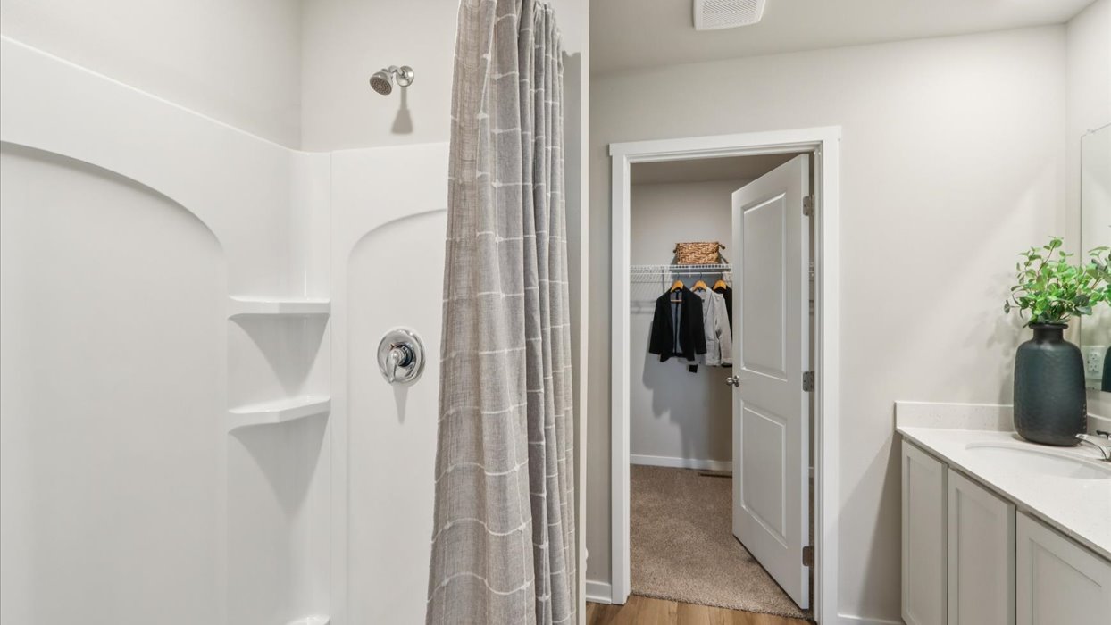 Spacious primary bathroom featuring dual vanities, modern fixtures, and a walk-in shower.