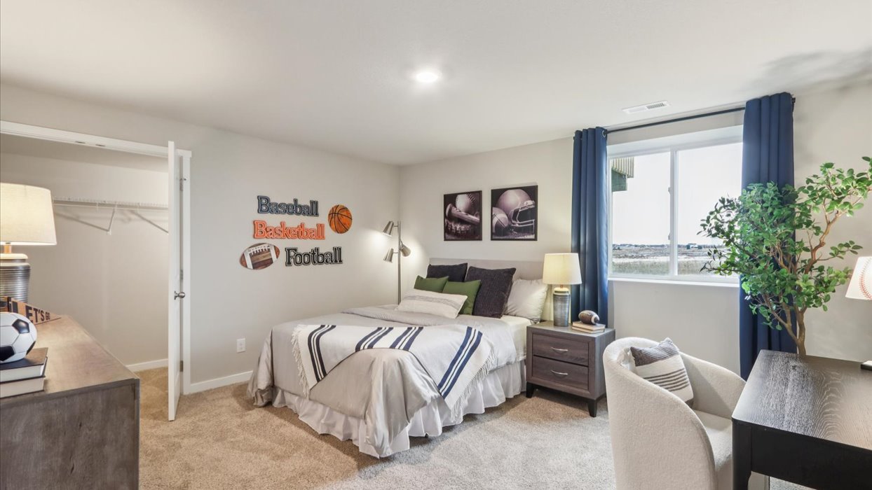 Private lower-level bedroom with natural light and functional storage space.