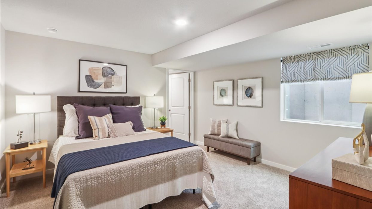Private lower-level bedroom with natural light and functional storage space.