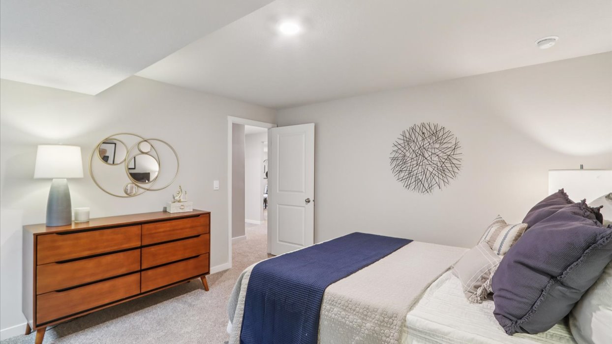 Private lower-level bedroom with natural light and functional storage space.