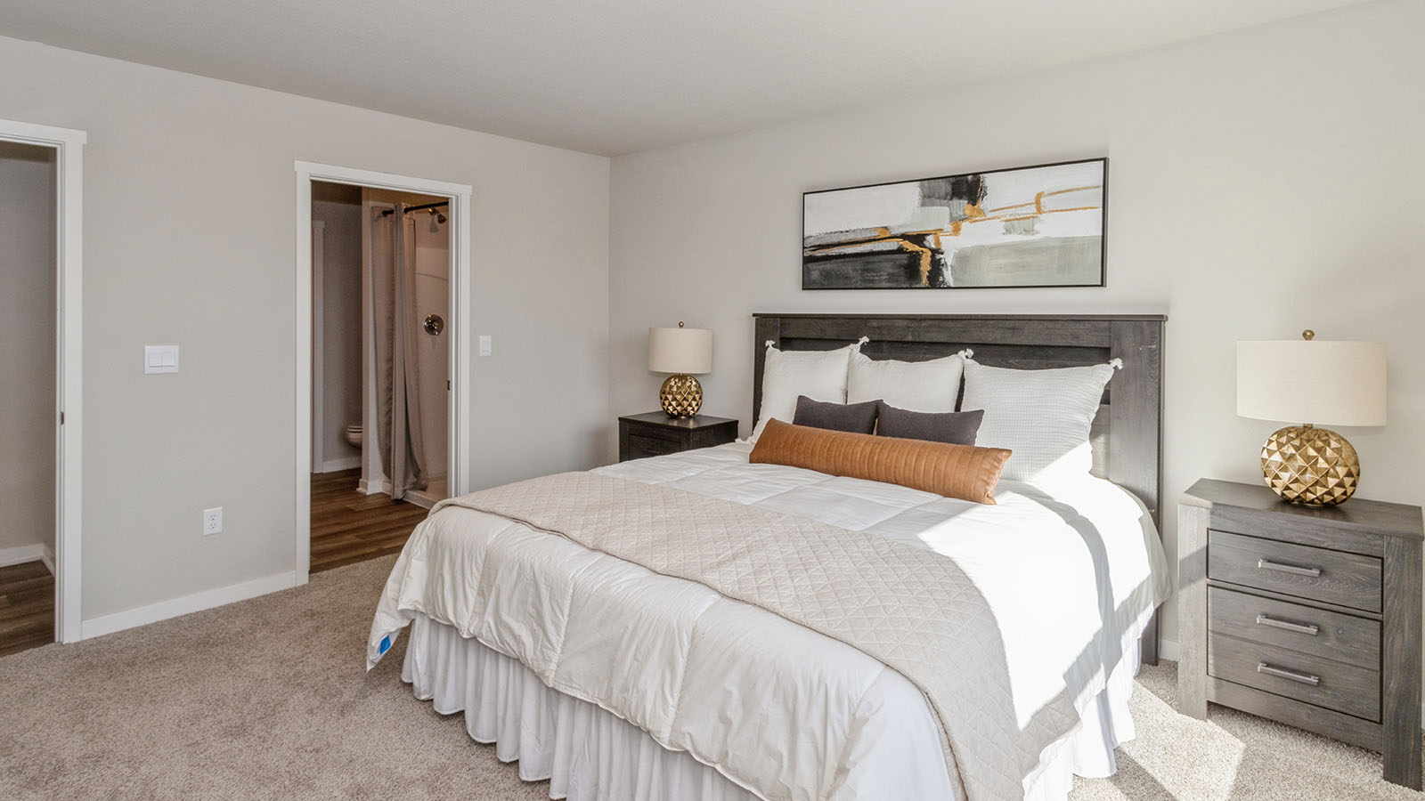 hamilton primary bedroom with large bed and view of primary bathroom