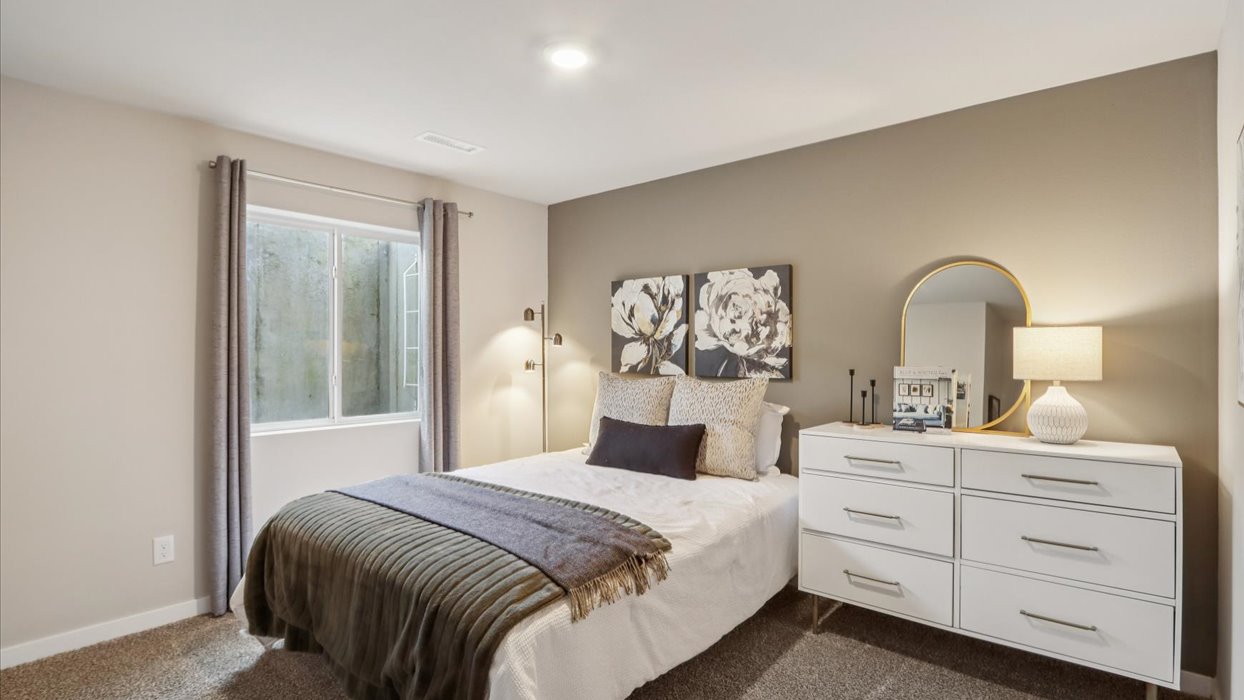 Private lower-level bedroom with natural light and functional storage space.