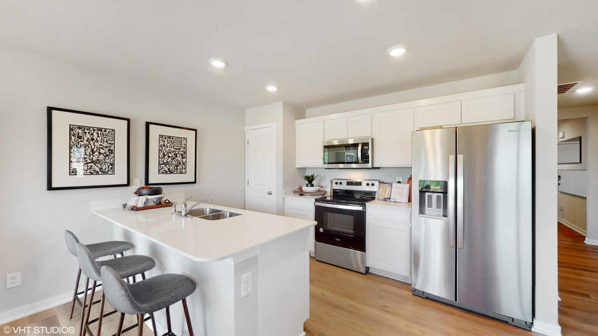 Kitchen with white, shaker-style cabinets, stainless-steel appliances, and white, quartz countertops in the Aldridge.