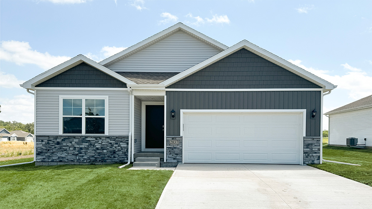 Exterior photo of the Aldridge with grey and white siding with stone and a 2 car-garage