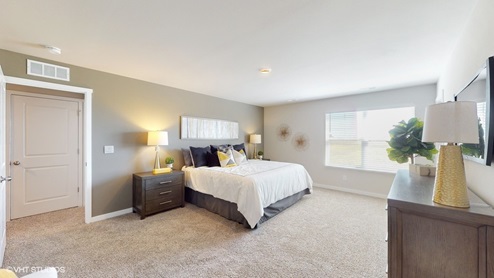 Primary bedroom of the Sydney with a king bed, two nightstands, and dresser