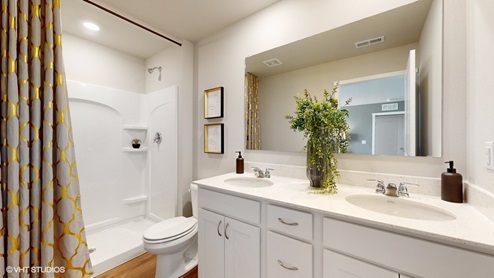 Primary bathroom of the sydney with dual sinks and a walk in shower