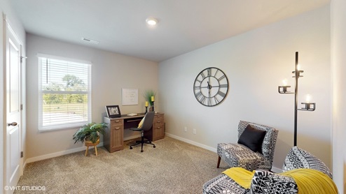 Second bedroom in the Sydney staged as an office with a seating area