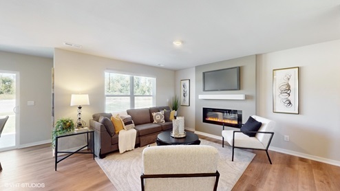Living room overview of the Sydney with a couch and two chairs around a fireplace