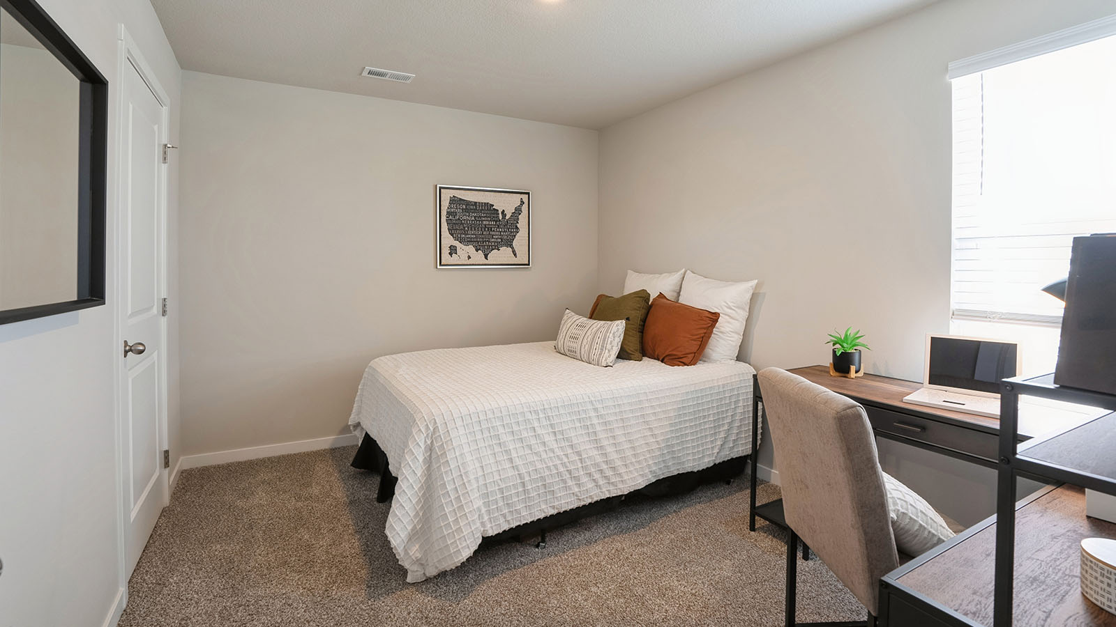 bedroom with beige carpet, white walls and a window