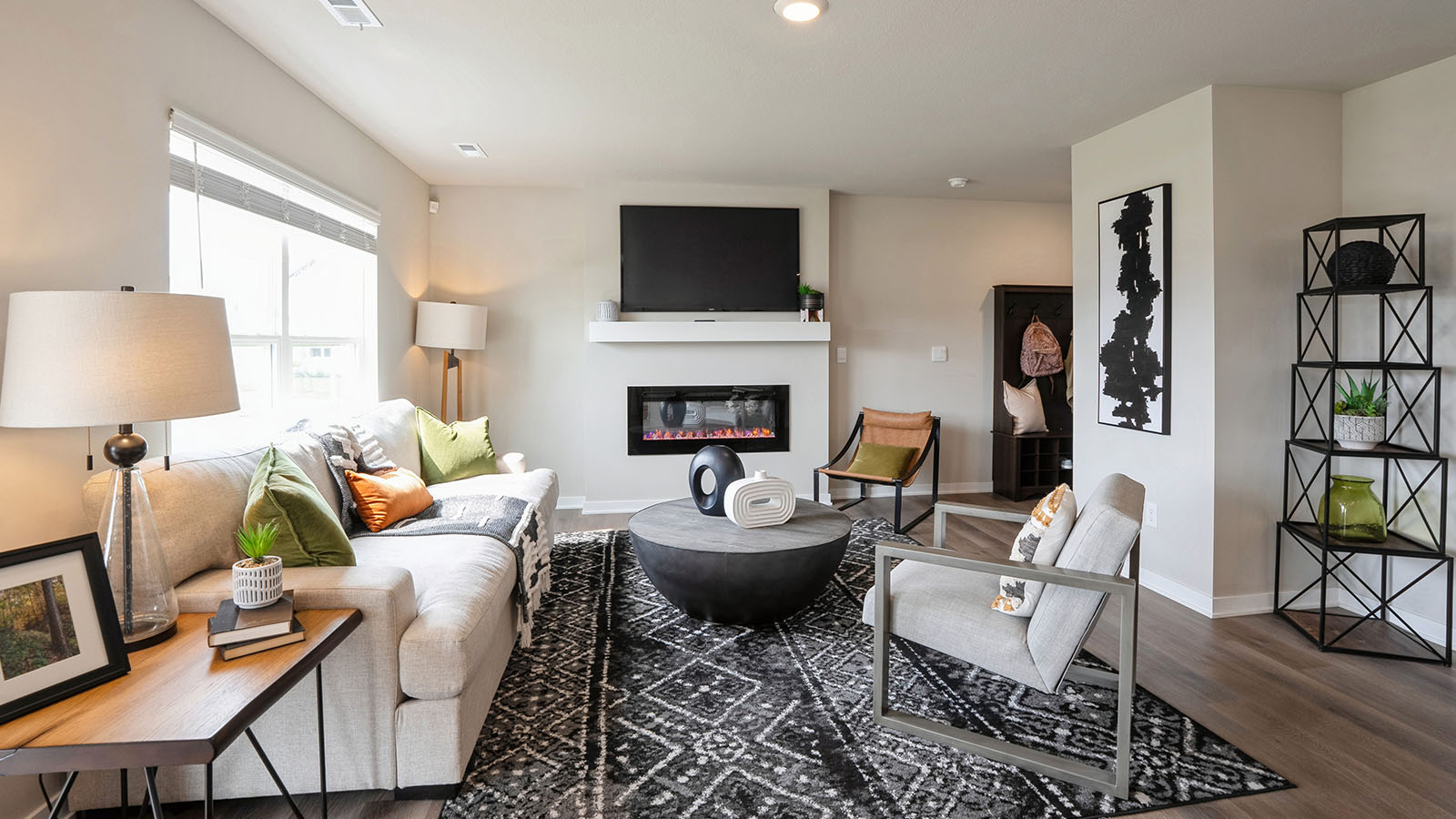 Spacious living room with brown flooring, white walls and windows