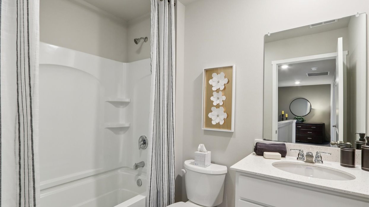 Bathroom with tub and shower combo, quartz countertops, and white vanity