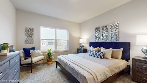 large primary bedroom with seating area and dresser