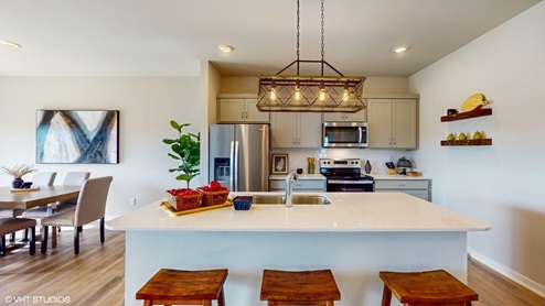 modern kitchen with light fixture and quartz countertops
